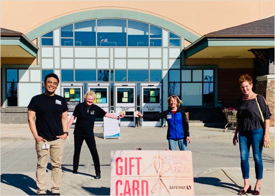 Safeway employees passing gift cards to customers while physical distancing.