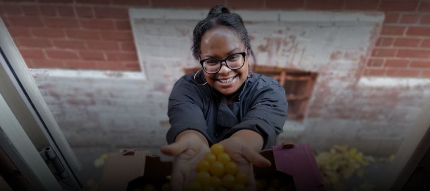 Cette image montre une dame offrant des baies, le sourire aux lèvres.